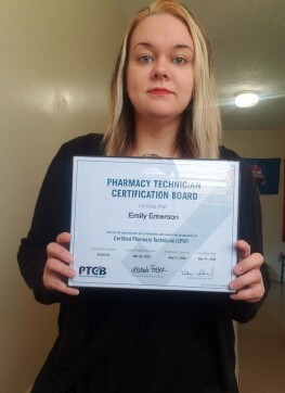 Emily Emerson holding her Pharmacy Technician certificate.