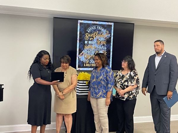 Niakeya Jones Cooper, Executive Director and Pam Hunt are looking at a certificate. 