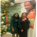 Barbara Huggins and another woman stand together in front of a banner that says: Congratulations Barbara Huggins. Adventure Awaits.
