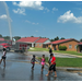 A group of children splashing in the water on a street.