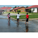 Children playing in the runoff from the water from a fire truck.