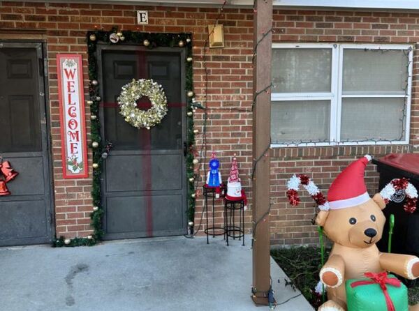 Wreath on the door with an inflatable bear and welcome sign.