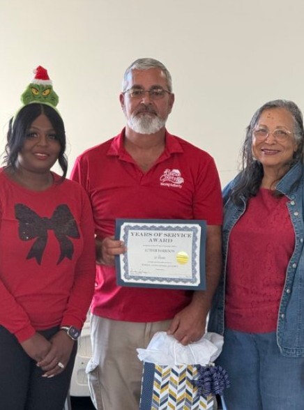 Luther Harrison smiling holding his service award.